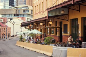 An outdoor seating area with tables and chairs, a sign for 'Gourmet Pizza', and a 'Australian Hotel' sign. - Australian Heritage Hotel (The Rocks)