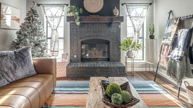 Een gezellige woonkamer met een open haard, een kerstboom en een comfortabele bank.