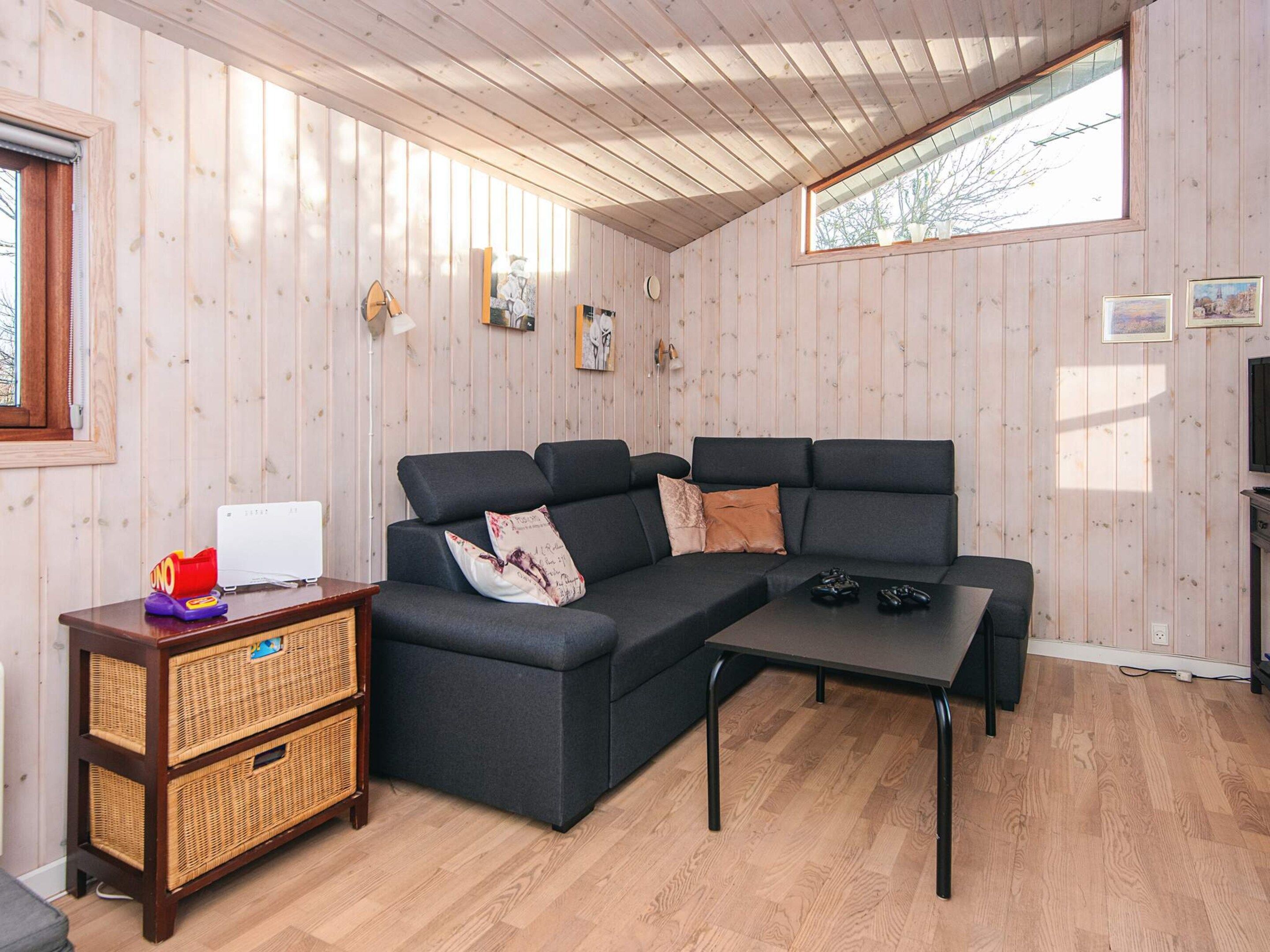 Una sala de estar acogedora con un sofá modular, una mesita de centro y unidades de almacenamiento de mimbre.