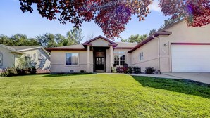 Une maison de plain-pied avec une porte d’entrée, un garage et une pelouse bien entretenue.