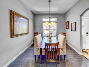 Enjoy meals in this dining area with a long table and comfortable chairs, surrounded by a beautiful view.