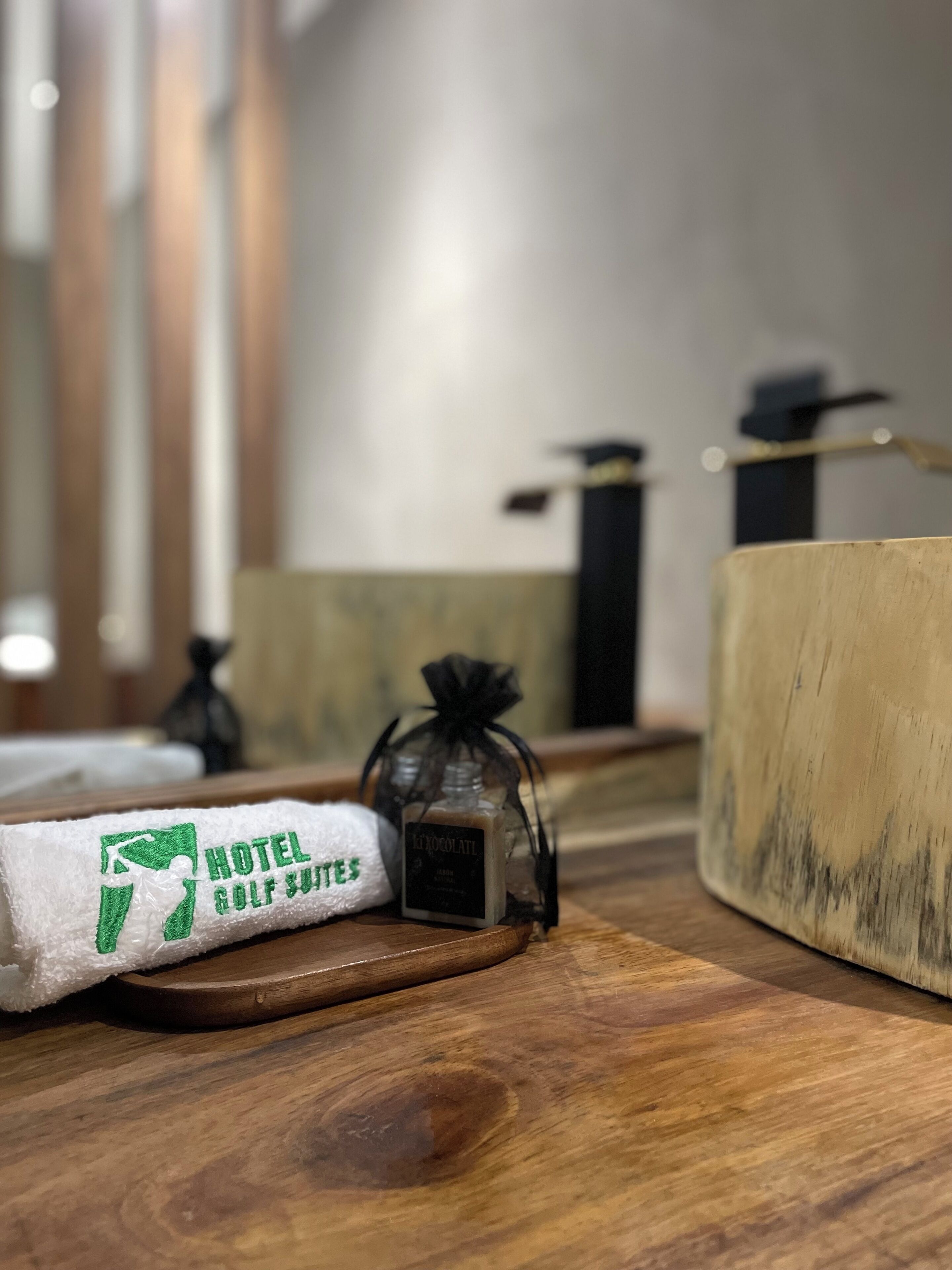 A wooden table with a towel, a bottle of soap, and a wooden block.