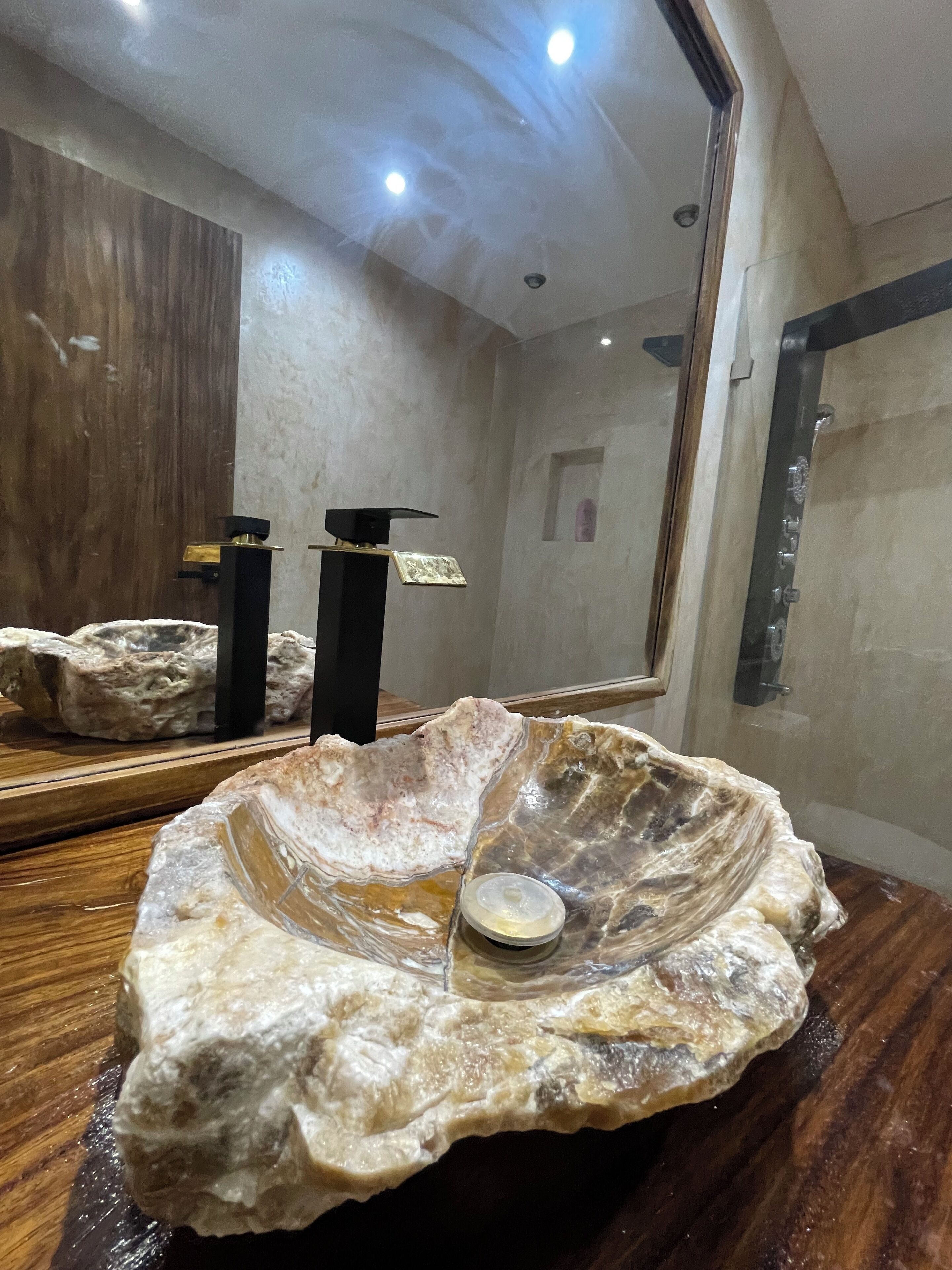 Un llamativo centro de mesa con forma de concha grande sobre una mesa de madera, con una vela pequeña en su interior.