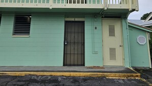 A two-story building with a balcony, a private property sign, and a door with a number 6.