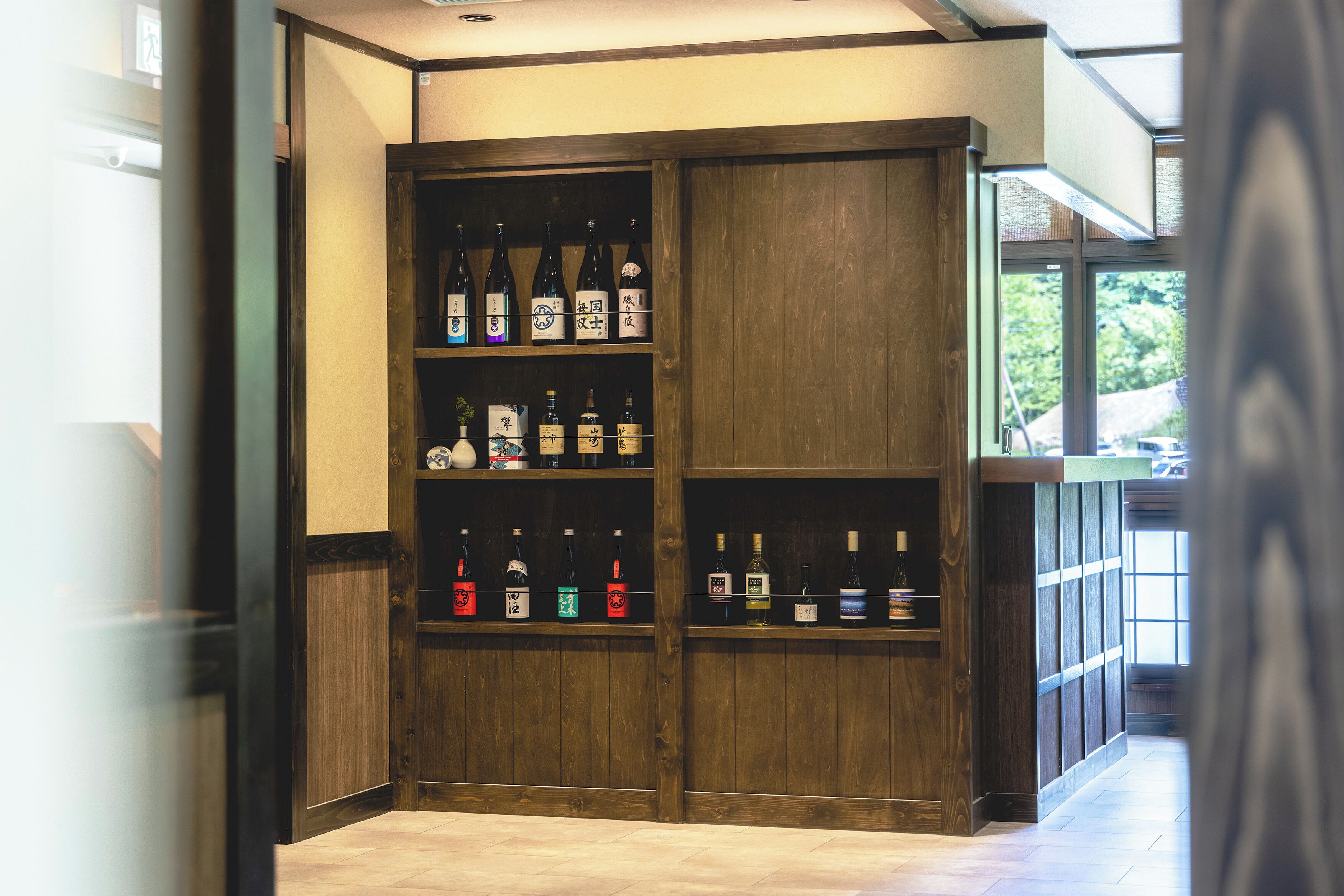 Een houten plankenwand met verschillende flesjes drank.