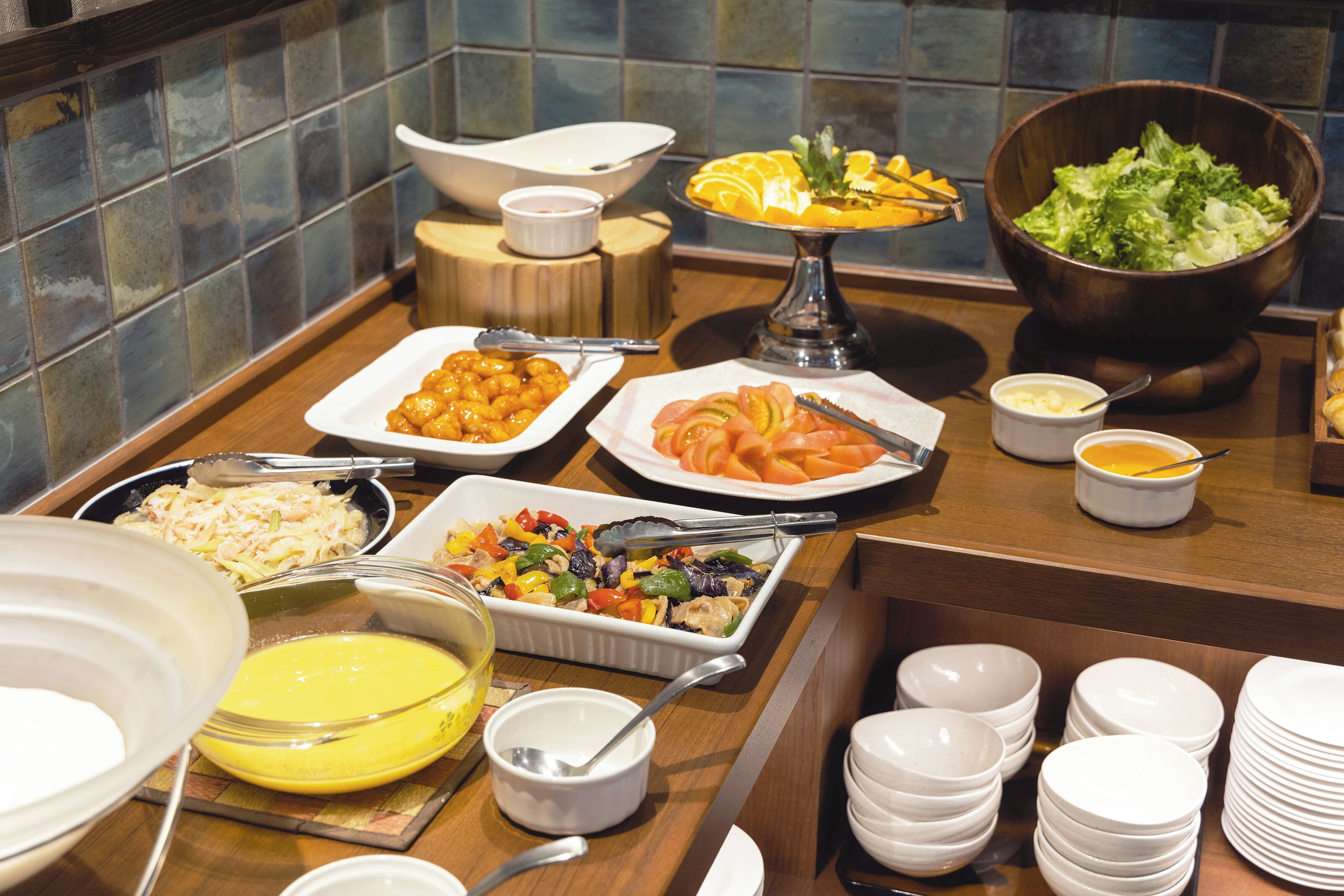 A buffet with various dishes including salads, fruits, and a variety of side dishes.