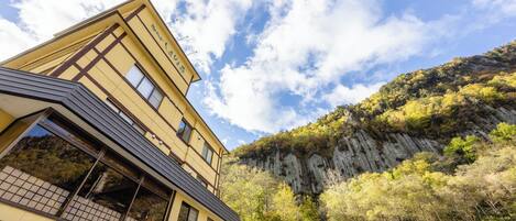 Un edificio de varios pisos con un estilo arquitectónico tradicional, que cuenta con amplios ventanales y un balcón.