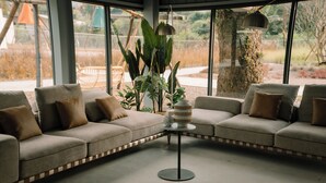 A modern living room with a sectional sofa, a small round table, and a hanging lamp. - BOHOLAND (Zhushan)