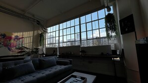 Ein modernes Wohnzimmer mit großem Fenster, einer Couch und einem Couchtisch.
