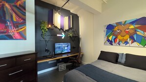 Ein modernes Schlafzimmer mit Bett, Schreibtisch und Computer.