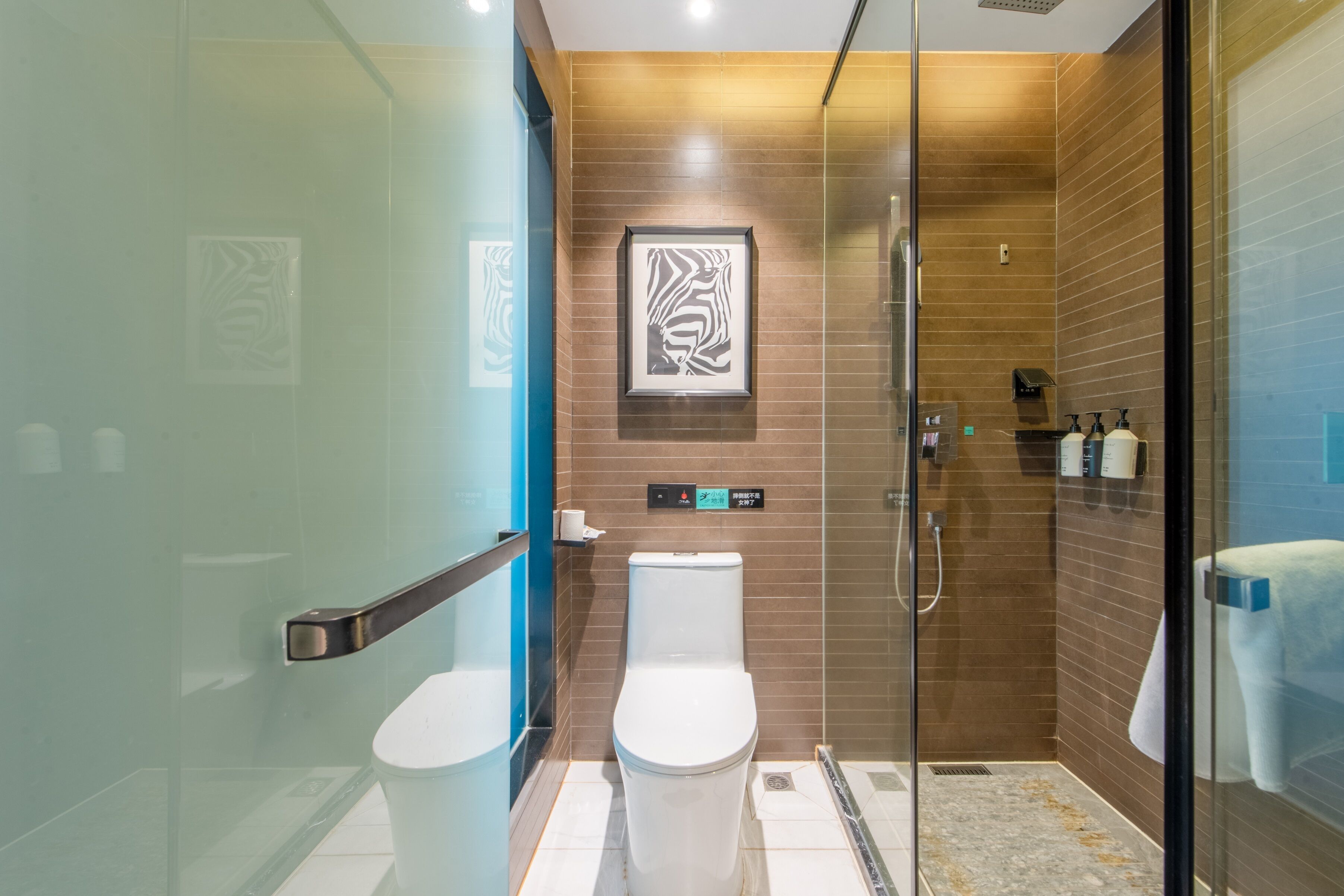 A modern bathroom with a glass shower enclosure, a toilet, and a sink.