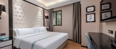 A modern hotel room with a large bed, a desk, and a window.