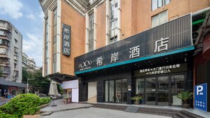 A hotel with a modern facade, large windows, and a sign indicating it is a XANA HOTEL. - Pazhou XANA Deluxe International Hotel Pazhou Convention and Exhibition Center Changgang Subway Metro Branch - Free Shuttle Bus to Canton Fair Complex During Canton Fair Period (Guangzhou)
