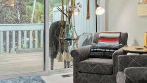 Una sala moderna con un ventanal grande, una planta colgante y una zona de estar acogedora.