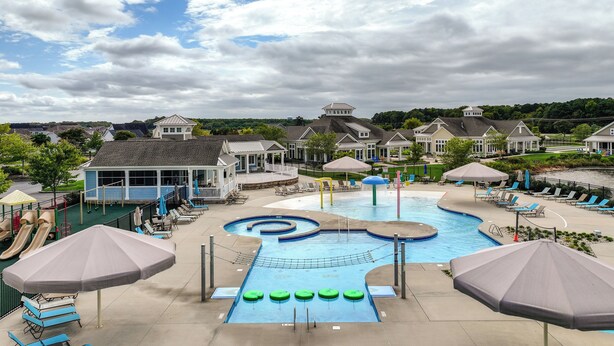 Un espace piscine équipé de toboggans, de chaises longues et de parasols.