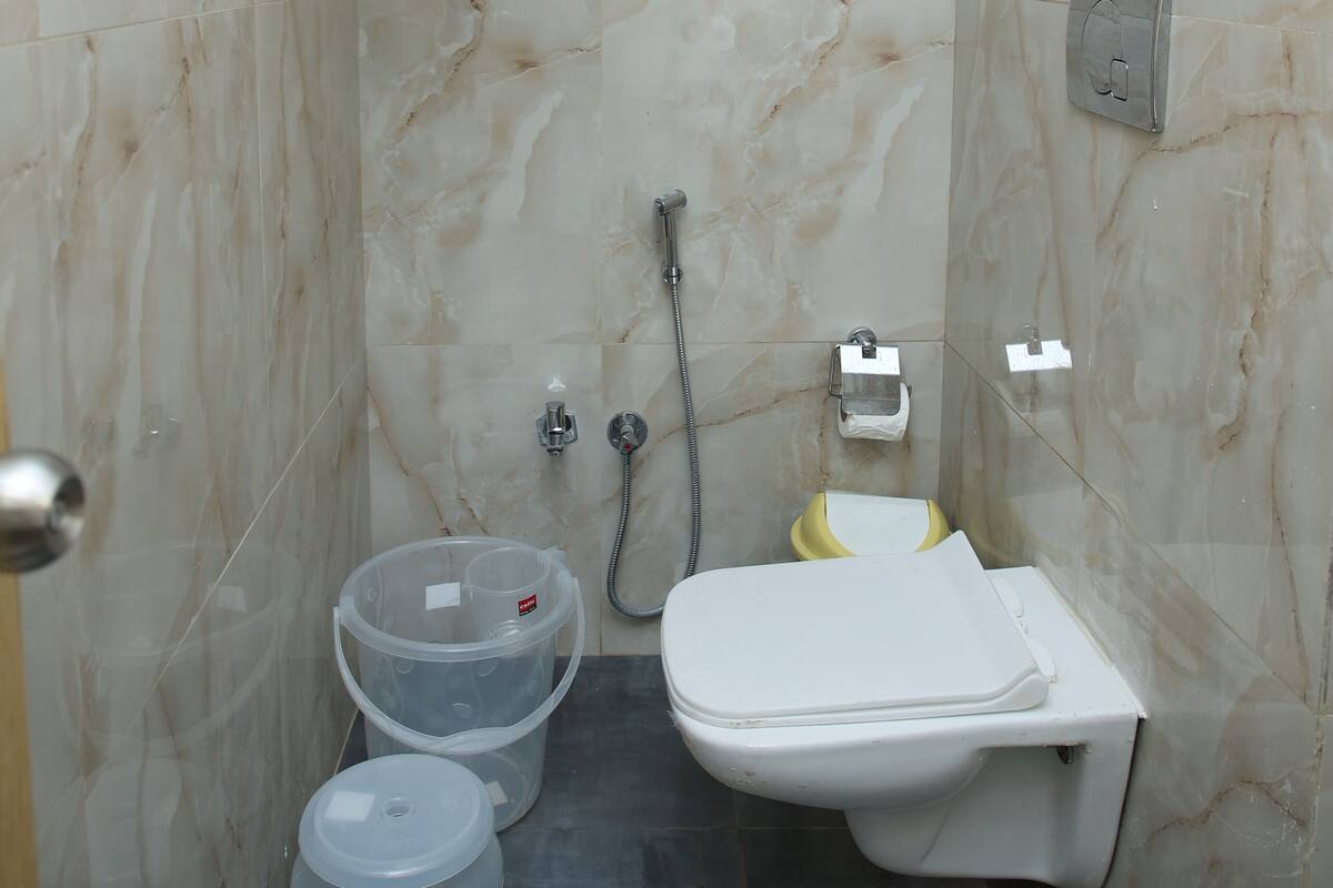 Un baño moderno con inodoro, ducha y perchero para toallas.