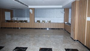 Un hall d’entrée spacieux doté d’un sol en marbre poli, de lambris en bois aux murs et d’un comptoir de réception agrémenté d’un miroir et d’objets décoratifs.