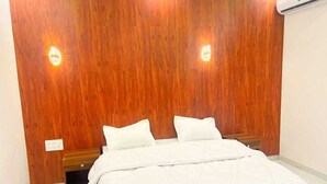 Une chambre à coucher avec une tête de lit en bois, deux oreillers blancs et une table de chevet en bois.