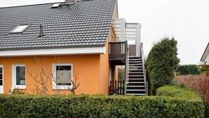 A house with a grey tiled roof, a white door, and a small window.