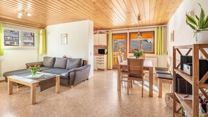 Un salon moderne avec un canapé, une table basse et un coin repas.