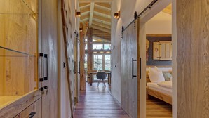 Un intérieur en bois avec un couloir central menant à un espace comprenant un lit et un bureau.