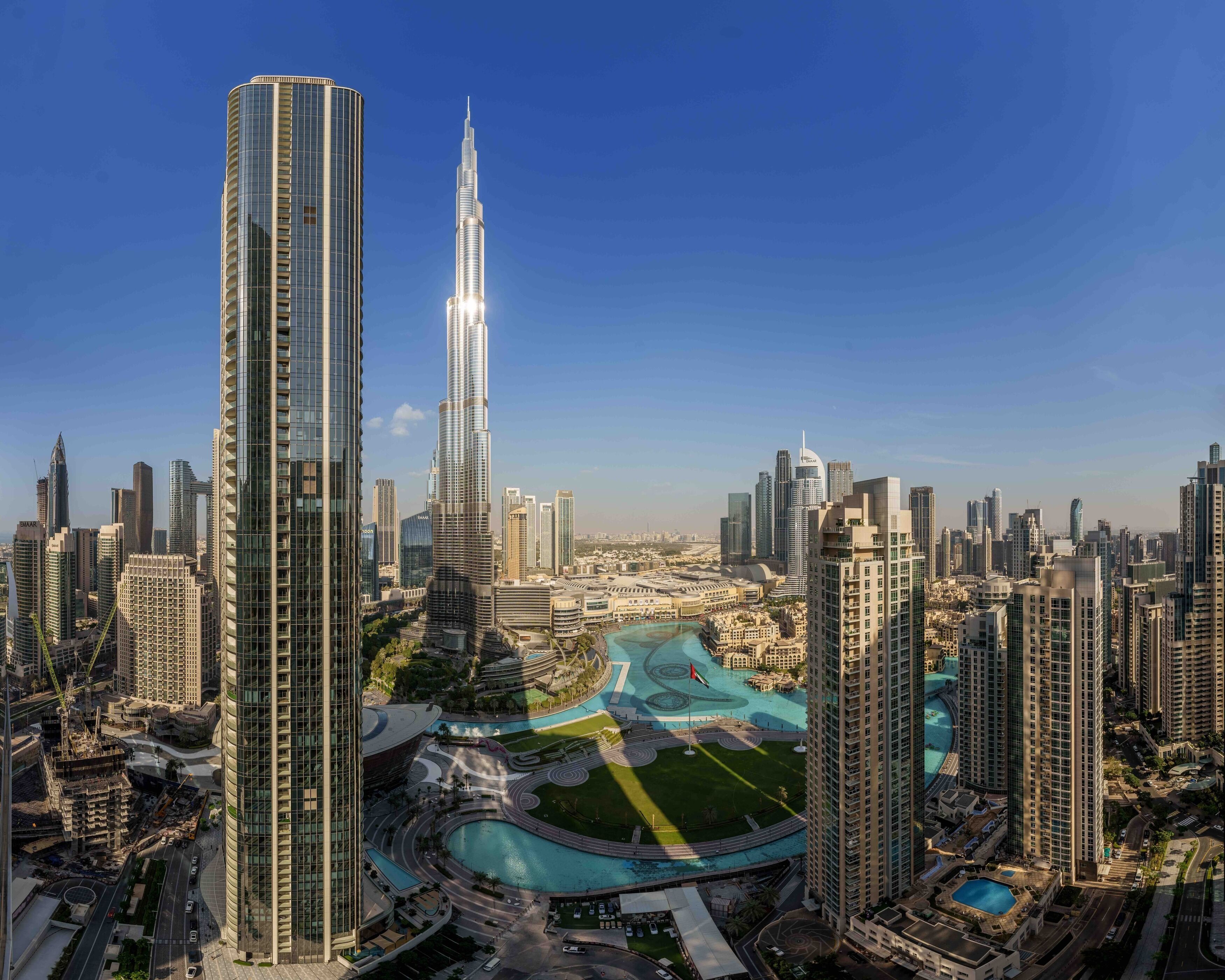 A high-rise building with a distinctive spire, surrounded by other tall buildings in a densely populated urban area.
