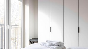 Una camera d'albergo con un letto, un tavolino e un armadio.