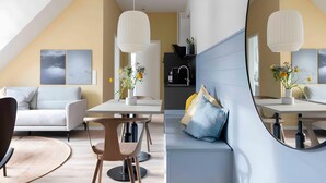Ein modernes Wohnzimmer mit einer Couch, einem Esstisch und einer Küchenzeile.