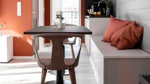 Een moderne keuken met een eethoek, met een tafel, stoelen en een bank.