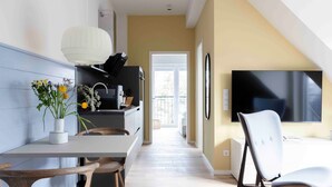 Una cocina moderna con comedor, televisión y vistas al exterior.