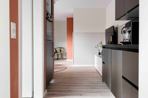 Una cocina moderna con horno empotrado y cafetera.