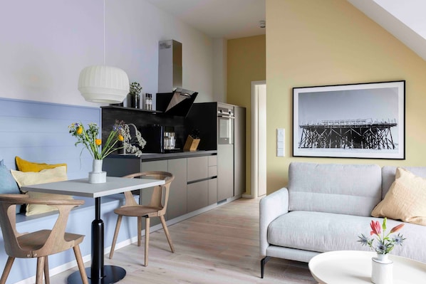 Une cuisine moderne avec un coin repas, un canapé et un tableau encadré au mur.