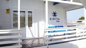 En vit byggnad med en blå logotyp och namnet ”KINITA Village”.