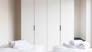 A hotel room with a bed, a wardrobe, and a mirror. - Apartment 'Quicksilver' with Balcony and Wi-Fi (Sankt Peter-Ording)