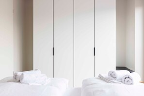 Une chambre d’hôtel avec un lit, une armoire et un miroir.