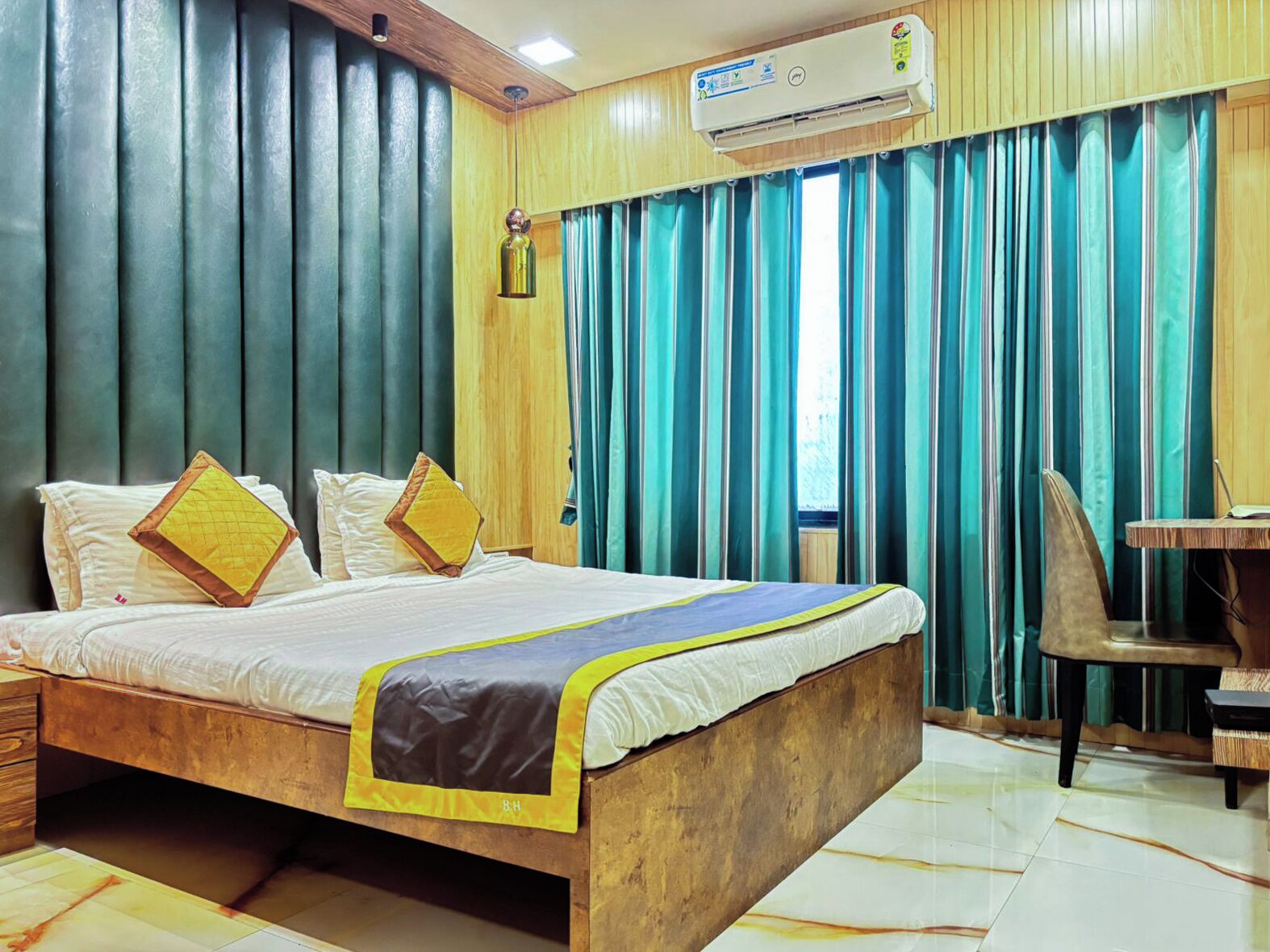 Une chambre d’hôtel équipée d’un lit, d’un bureau et d’un appareil de climatisation.