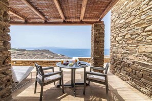 A stone-walled balcony with a wooden ceiling overlooking a coastal landscape. - Dolce Villa Tinos Kardiani in Stone & Sunset Views (Kardiani)