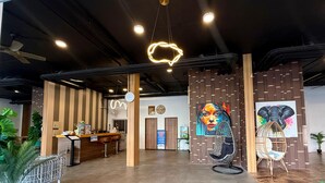 A modern reception area with a wooden reception desk, seating, and a large wall mural.