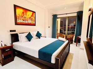 Relax in a spacious room with a large bed, a comfortable nightstand, and a sliding door leading to a balcony with seating.
