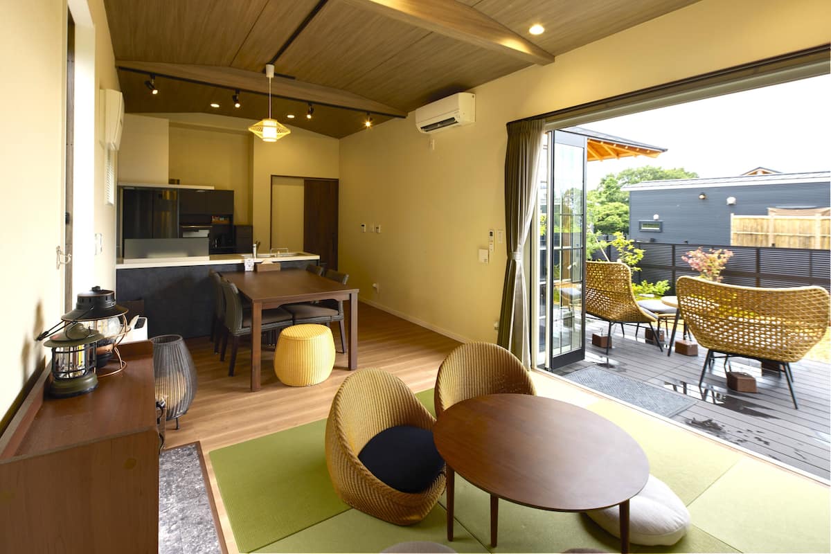 Un interior moderno con comedor, cocina y vistas a la terraza exterior.