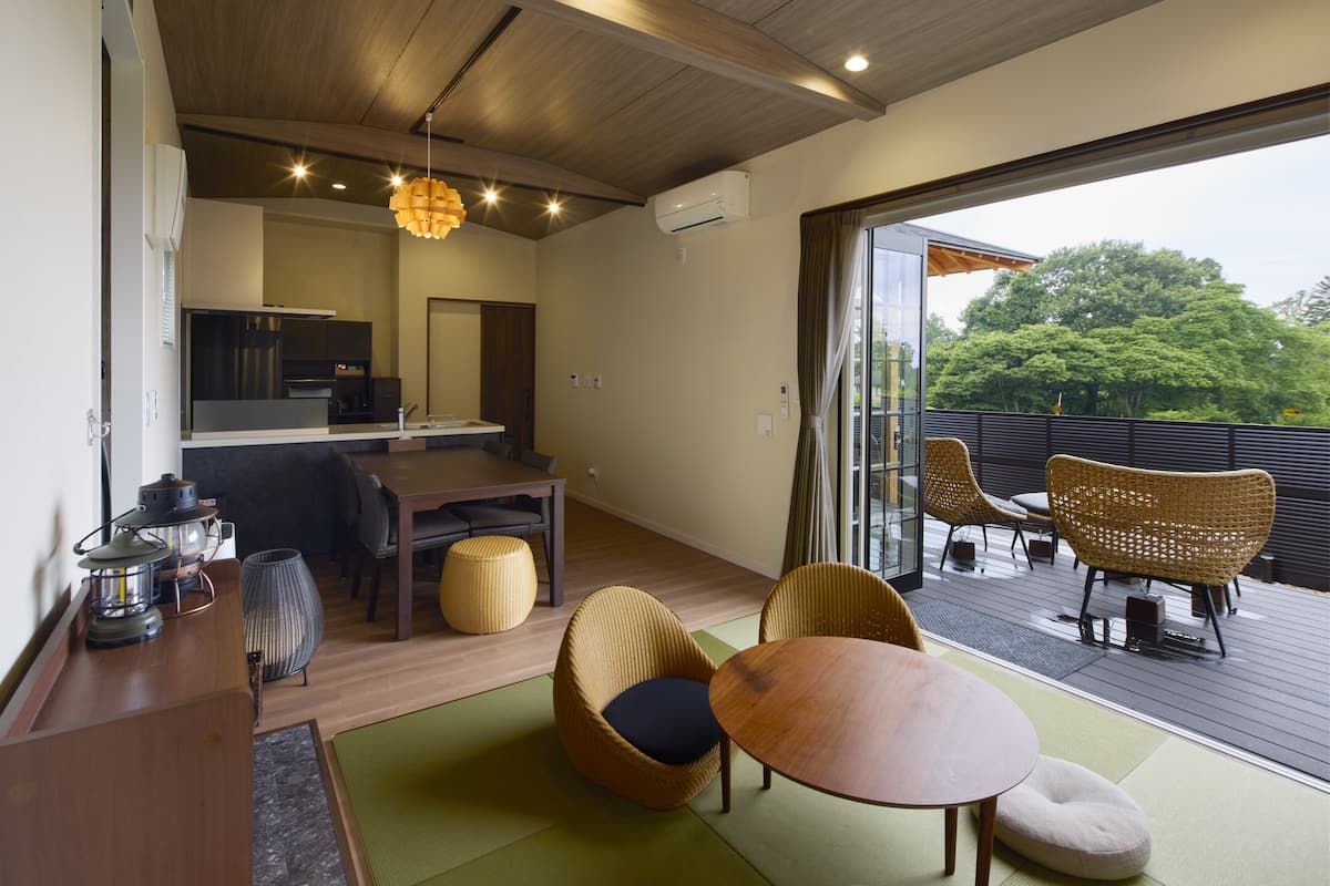 Un interior moderno con comedor, cocina y vistas al exterior.