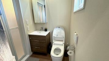 Een bad/douchecombinatie, een haardroger, handdoeken, shampoo