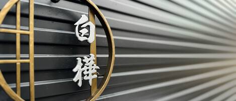 A close-up of a metal sign with Chinese characters, mounted on a curved metal structure.