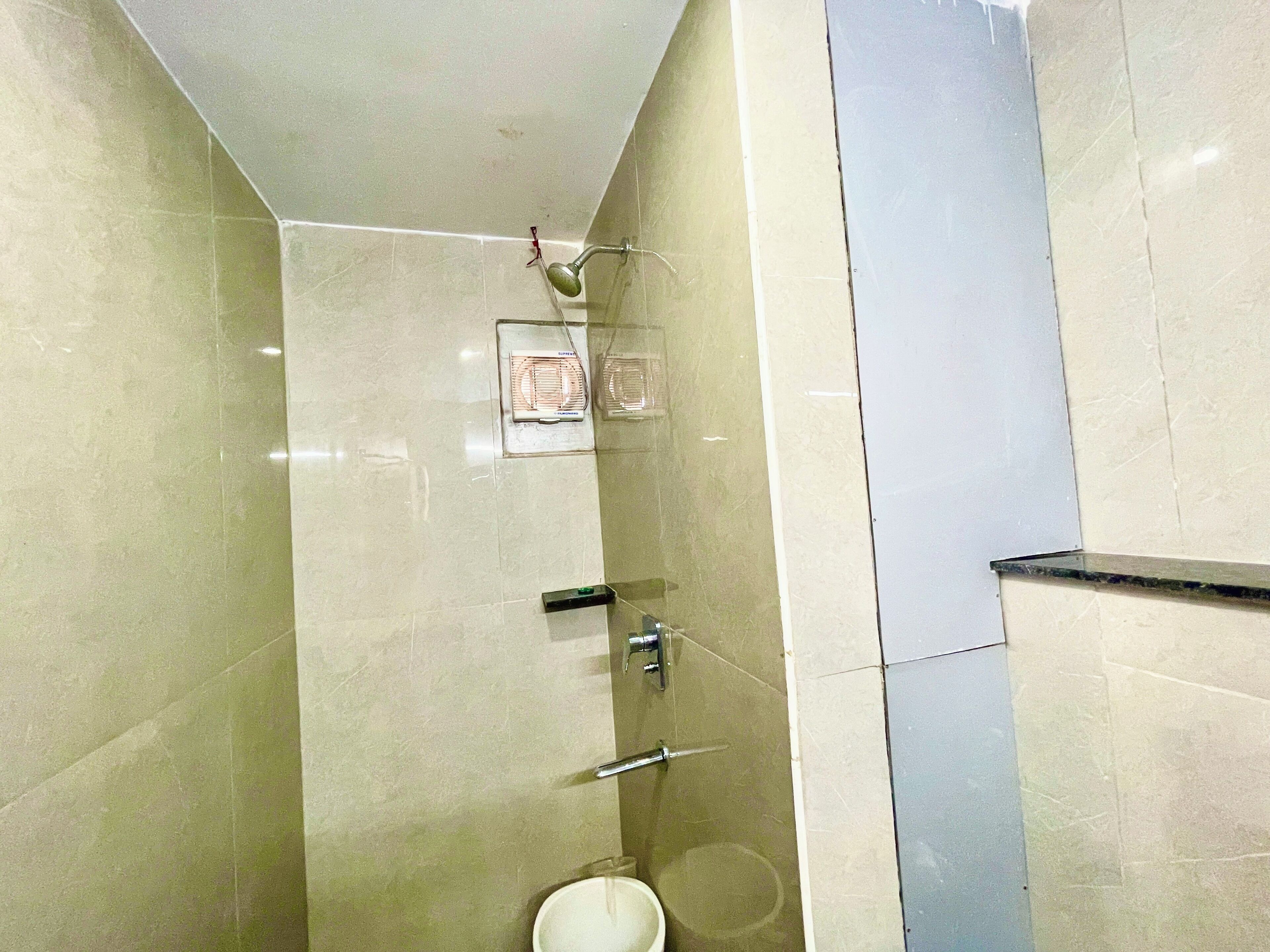 Een badkamer met een toilet, een douche en een handdoekrek.