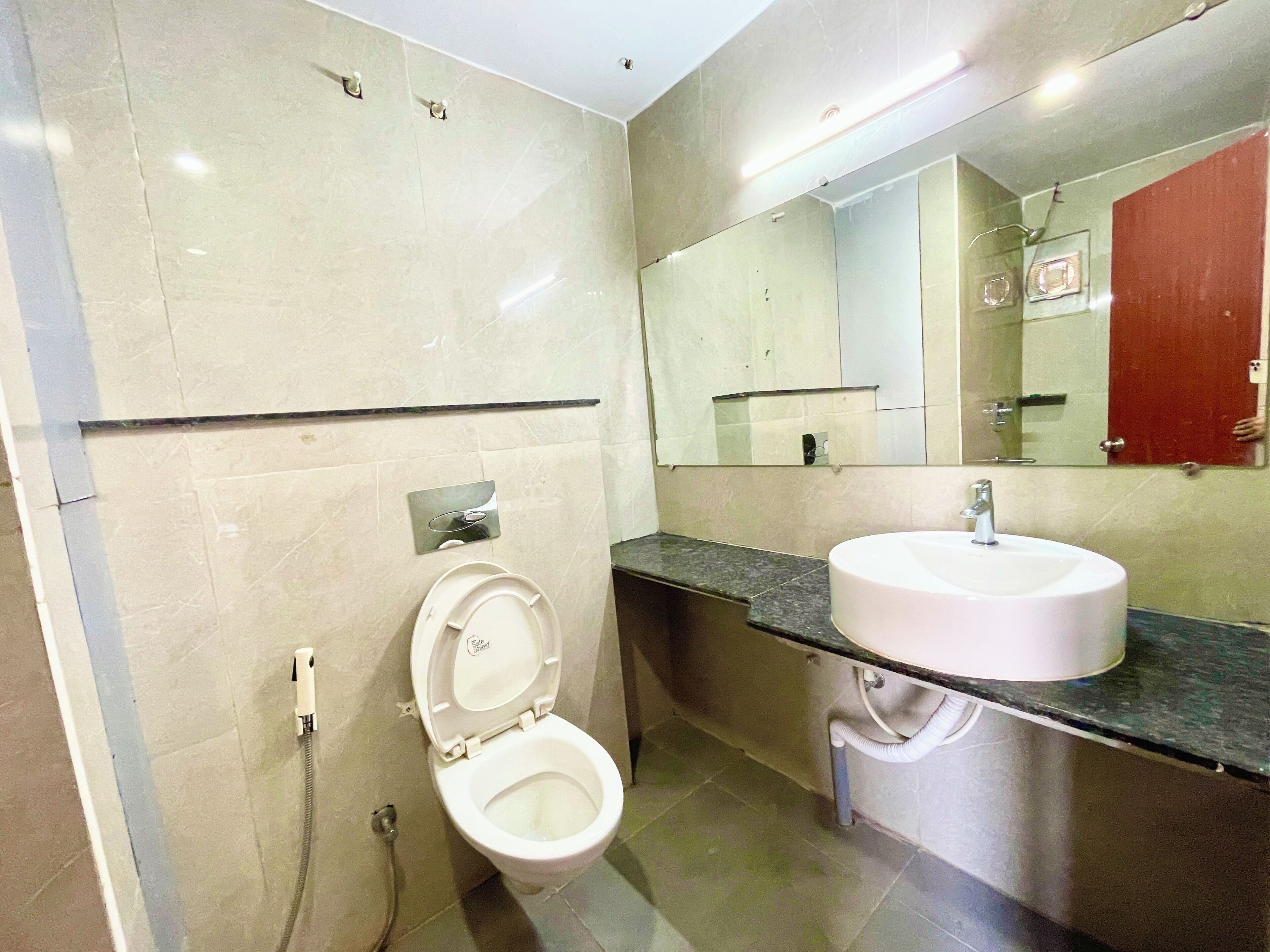 Une salle de bain moderne avec des toilettes, un lavabo et un miroir.