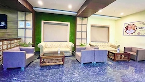 A lobby with two sofas, a coffee table, and a reception desk. - Hotel Janaki Pride - near Temple (Puri)
