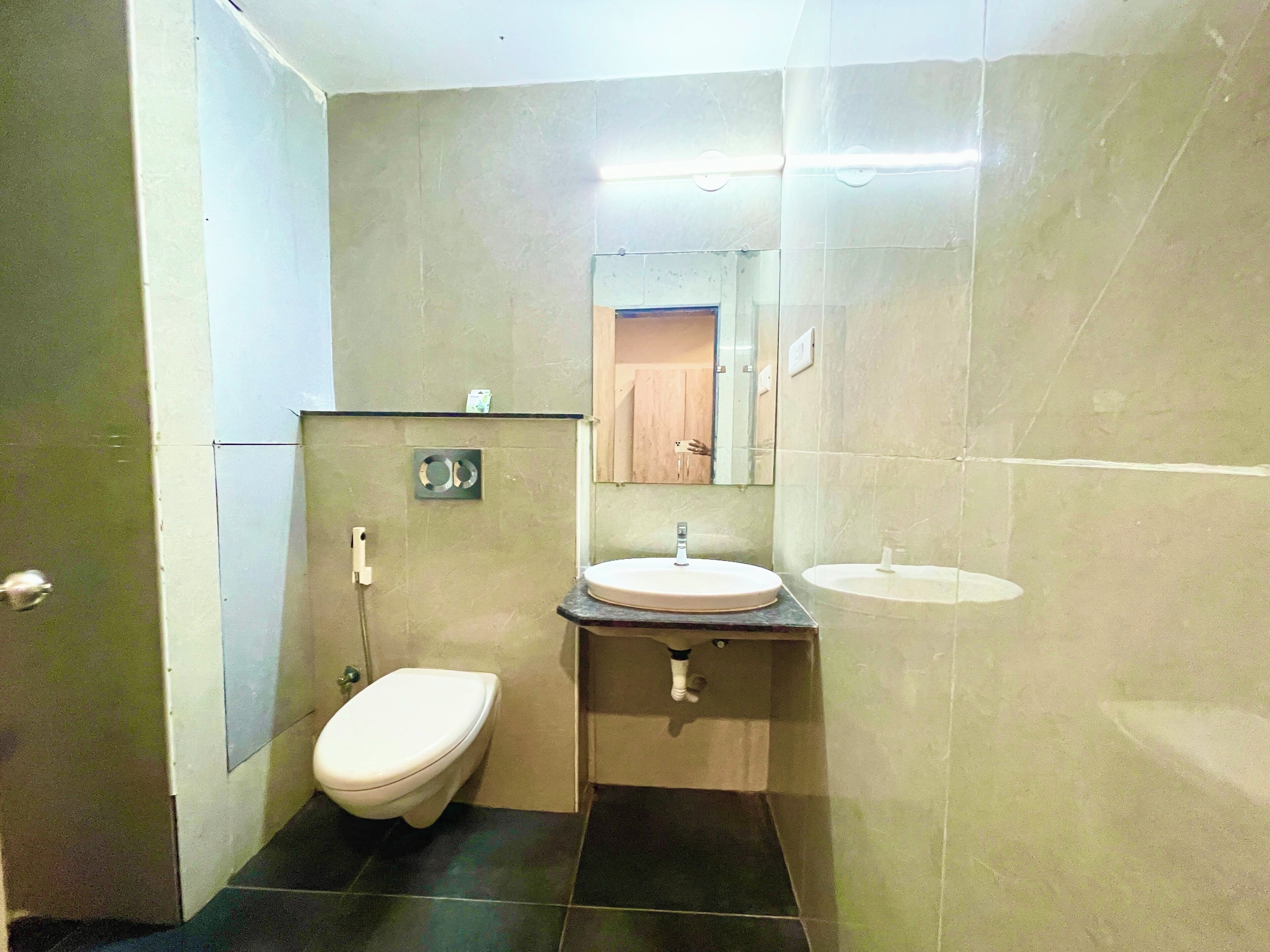 Une petite salle de bain avec des toilettes, un lavabo et un miroir.