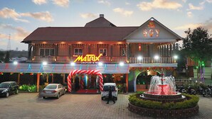 Een hotel met een opvallend Matrix-bord, een fontein en een goed verlichte entree.