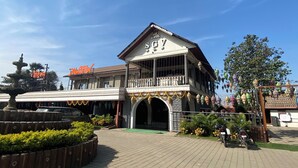 A building with a sign reading "The SGY" and a balcony with railings. - The Saroja Grand Villa Resorts (Vasai)