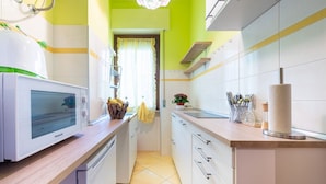 A kitchen with a microwave, sink, cabinets, and a window with curtains. - Cosy apartment of 34 sqm, for 2 people, on the fourth floor of a building with lift (with some steps to access it).The property is located in a lively district and well served by public transport; the apartment is 50 m from the Hospital of Parma and a fe (Parma)